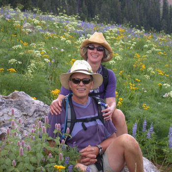 Man and Woman Smiling by Wildflowers on Jackson Hole Hiking Tour - Hole Hiking Experience